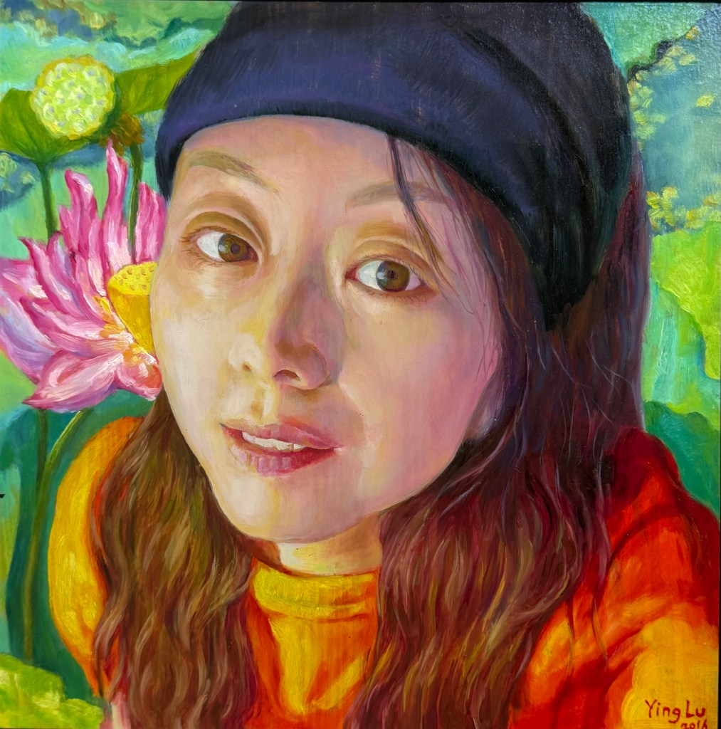 A self-portrait of an artist with long hair, wearing a black beanie and an orange top, surrounded by colorful flowers in the background.